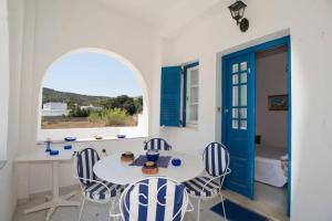 comedor con mesa y sillas y puerta azul en Lovely House Infront Of The Beach In Molos, en Molos Parou