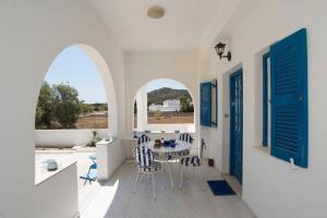 a dining room with blue doors and a table and chairs at Lovely House Infront Of The Beach In Molos in Molos Parou