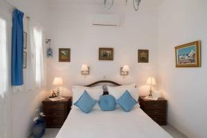 1 dormitorio con 1 cama grande con almohadas azules en Lovely House Infront Of The Beach In Molos, en Molos Parou