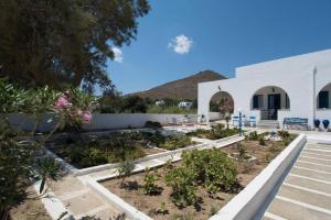 un jardín frente a un edificio blanco en Lovely House Infront Of The Beach In Molos, en Molos Parou