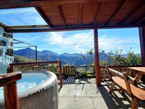 a patio with a hot tub and a table and bench at Finca Ancestros in Tejeda