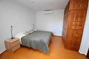 a small bedroom with a bed and a wooden door at Casa Vista Montgo Javea - 5048-3 in Balcon del Mar