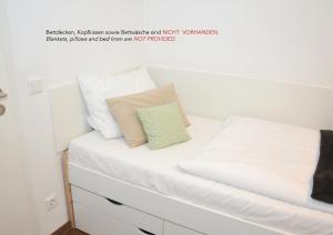 uma cama com lençóis brancos e uma almofada em WG Zimmer in der World of Living K em Regensburg