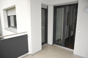 duas janelas num quarto com paredes brancas em WG Zimmer in der World of Living K em Regensburg