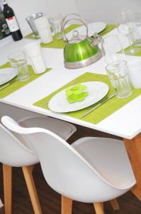 uma mesa de jantar branca com uma chaleira de chá verde em WG Zimmer in der World of Living K em Regensburg
