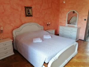 una camera da letto con un letto bianco e uno specchio di Alloggio Margherita a Torino