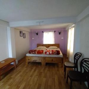 1 dormitorio con 1 cama, mesa y sillas en Hunsi Homestay, en Sohrārim