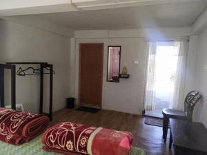 1 dormitorio con cama, mesa y ventana en Hunsi Homestay, en Sohrārim