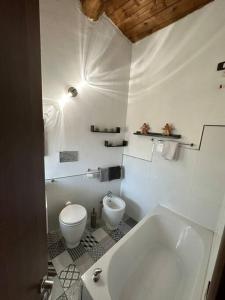 a white bathroom with a tub and a toilet at Casa Vacanze Stezzano in Stezzano
