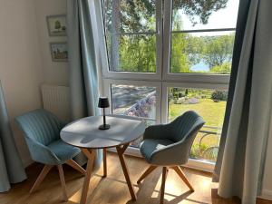 a table and two chairs in front of a window at Ferienzimmer Suhrer Seeblick in Plön