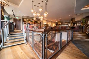 a restaurant with stairs and a bar with chandeliers at Miller & Carter Sheffield by Innkeeper's Collection in Sheffield