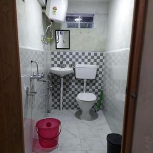 a small bathroom with a toilet and a sink at Hunsi Homestay in Sohrārim