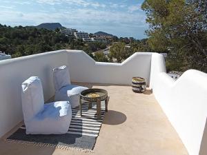 a patio with two chairs and a table on a balcony at wonderful sunsets views from terraces Last minute in Cala Vadella