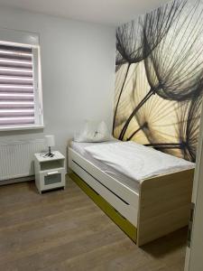 1 dormitorio con 1 cama con una pintura en la pared en Ferienwohnung Da Emi, en Neunkirchen