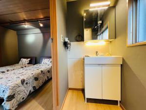 1 dormitorio con cama, lavabo y espejo en Ueno house, en Tokio