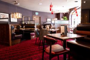 a restaurant with tables and chairs and a piano at Miller & Carter Sheffield by Innkeeper's Collection in Sheffield