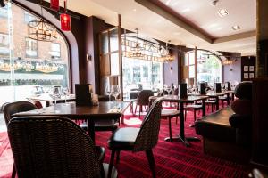 a restaurant with tables and chairs and windows at Miller & Carter Sheffield by Innkeeper's Collection in Sheffield