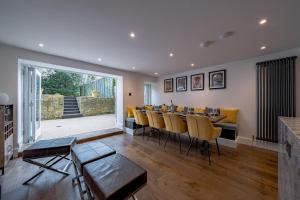 a dining room with a long table and yellow chairs at Luxurious GRAND 6 BR Home in BATH - Perfect for Groups & Sleeps 12! in Bath