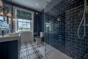 a bathroom with a sink and a glass shower at Luxurious GRAND 6 BR Home in BATH - Perfect for Groups & Sleeps 12! in Bath