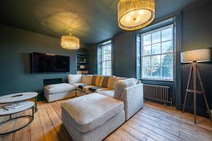 een woonkamer met een bank en een tafel bij Luxurious GRAND 6 BR Home in BATH - Perfect for Groups & Sleeps 12! in Bath