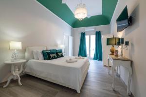 a bedroom with a white bed and a green ceiling at Domus Federiciana in Castellammare del Golfo