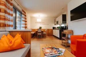 a living room and kitchen with a couch and a table at Burgls Apartmenthaus in Tröpolach