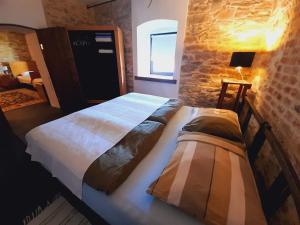 two beds in a bedroom with a brick wall at Statek "Two brooms", Apartment in Mirkovice