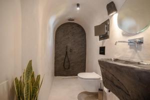 a bathroom with a shower and a toilet and a sink at One of One - Aether in Oia