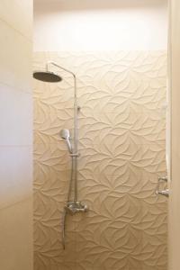 y baño con ducha y papel pintado de olas. en Villa Armeni by CorfuEscapes, en Corfú
