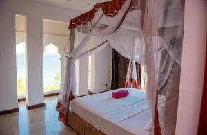 Un dormitorio con una cama con un corazón rosado. en Lux Suites Shanzu Beachfront Apartments, en Shanzu