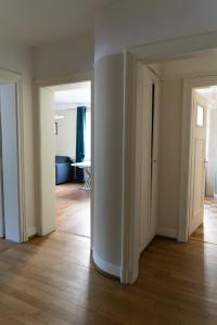 an empty room with white walls and wooden floors at Yapot in Colmar