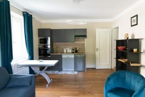 a kitchen with a table and blue chairs in a room at Yapot in Colmar