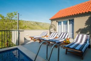 a patio with two lounge chairs and a swimming pool at Holiday Home Moliva in Donje Sitno