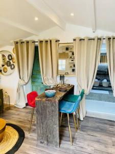 een keuken met een tafel, stoelen en gordijnen bij Cottage, Lodge & Spa in Prouilly