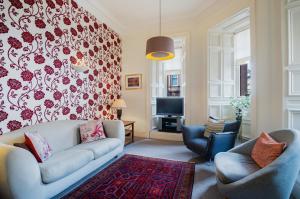sala de estar con sofá y 2 sillas en West George Street Apartment en Glasgow