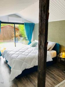 een slaapkamer met een groot bed en een raam bij Cottage, Lodge & Spa in Prouilly