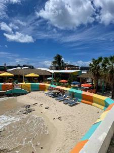 una spiaggia con sedie e ombrelloni sulla sabbia di Charming Maho Beach Bar Studio a Maho Reef