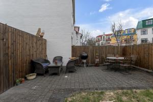 a patio with chairs and a table and a fence at Spacious, Cozy & Family Friendly House in Reykjavík