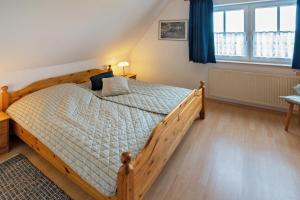 a bedroom with a wooden bed with blue curtains at Ferienwohnung Mareike in Dornum
