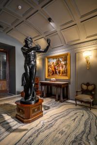 uma estátua numa sala com uma mesa e um quadro em Grand Hotel Parker's em Nápoles