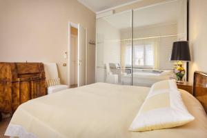 a bedroom with a large white bed and a table at Villetta Olivi - Vista mozzafiato in Torri del Benaco +10 photos