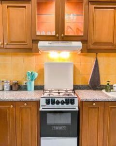 a stove top oven in a kitchen with wooden cabinets at Snooze Malang in Malang