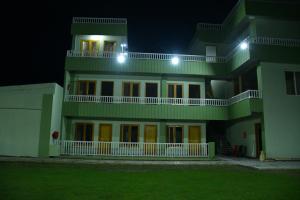 a large green building at night with lights at Maharani Garden in Haldwāni +5 photos