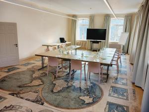 a room with a table with chairs and a tv at Kloster Bonlanden in Berkheim