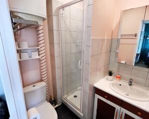 Un baño con ducha, inodoro y lavabo. en Studio Lumineux- à 15 min de Paris, en Bois-Colombes