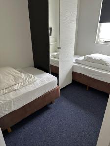 een slaapkamer met 2 bedden en een spiegel bij Prins Heerlijk Amelander Kaap 81 in Hollum