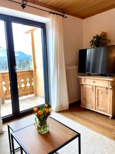 een woonkamer met een tafel en een groot raam bij Landhaus Barbara in Kitzbühel