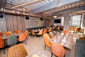 a dining room with tables and chairs and a flat screen tv at СПА Хотел Романтика in Sarnitsa