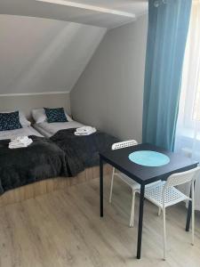 een slaapkamer met 2 bedden en een tafel en stoelen bij Pokoje na Górce in Rajgród