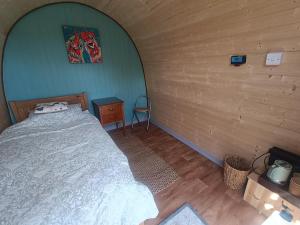 a bedroom with a bed in a wooden room at MotoCamp Wales in Dolgellau